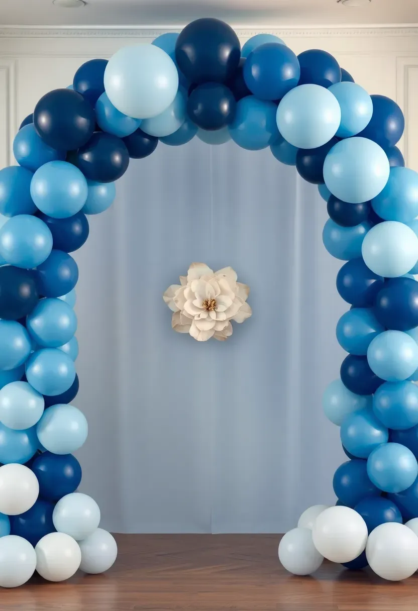blue ombre balloon arch transitioning navy to ice blue with white paper flowers and floor balloons below