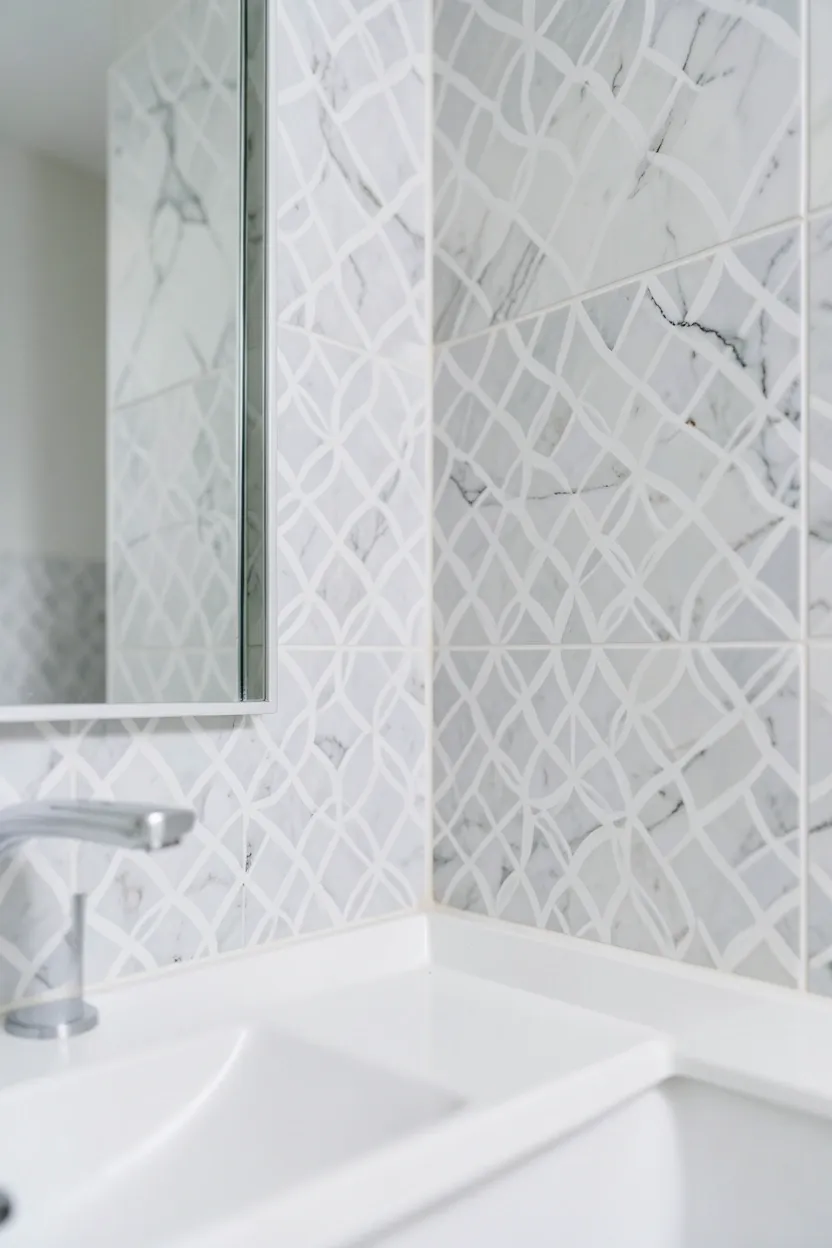 Subtle geometric accent tile backsplash in neutral tones behind a modern vanity in a mansion bathroom
