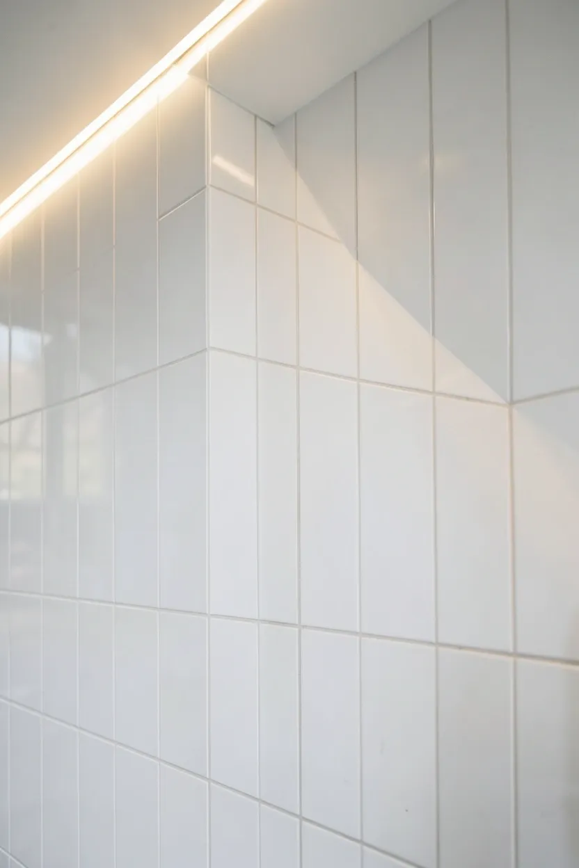 White subway tiles in vertical stack pattern floor to ceiling creating height illusion in small rental bathroom