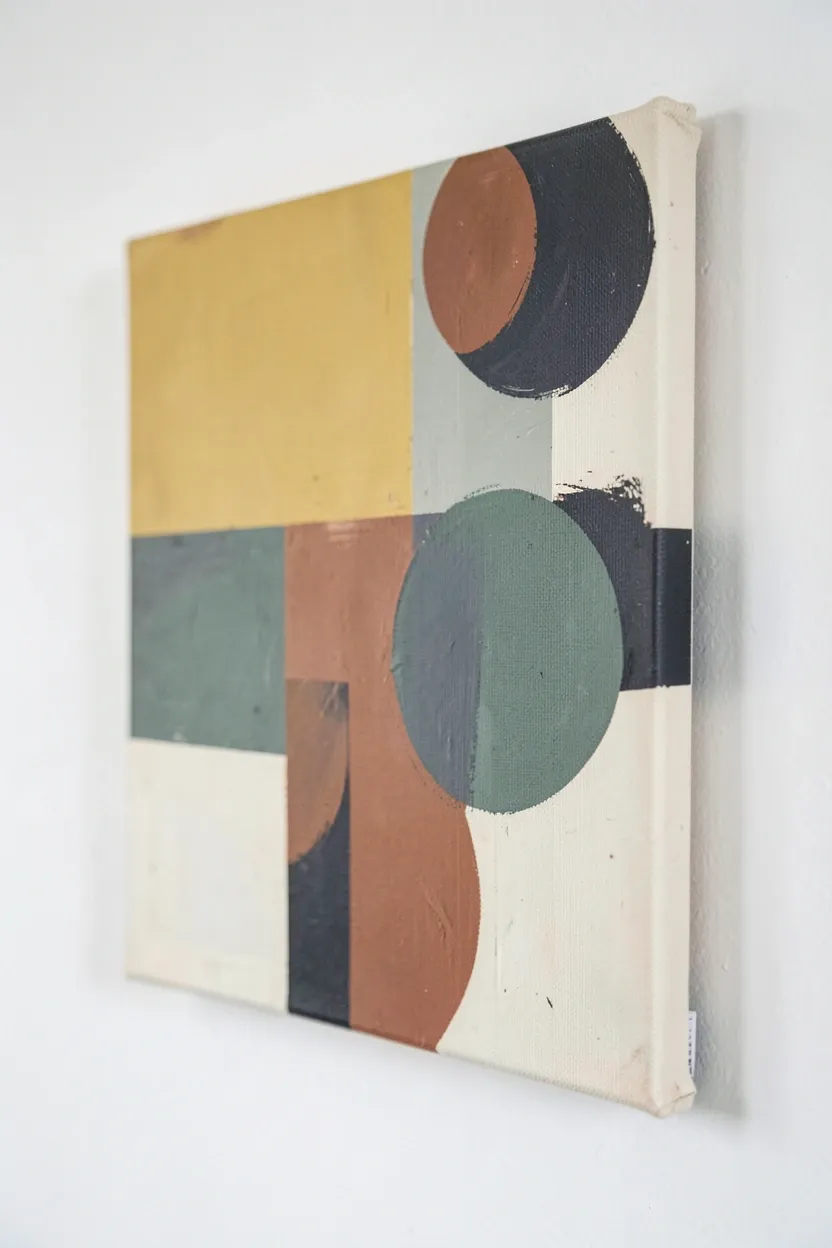 Vintage Scandinavian abstract art print in mustard, terracotta, and sage green earth tones on a white living room wall